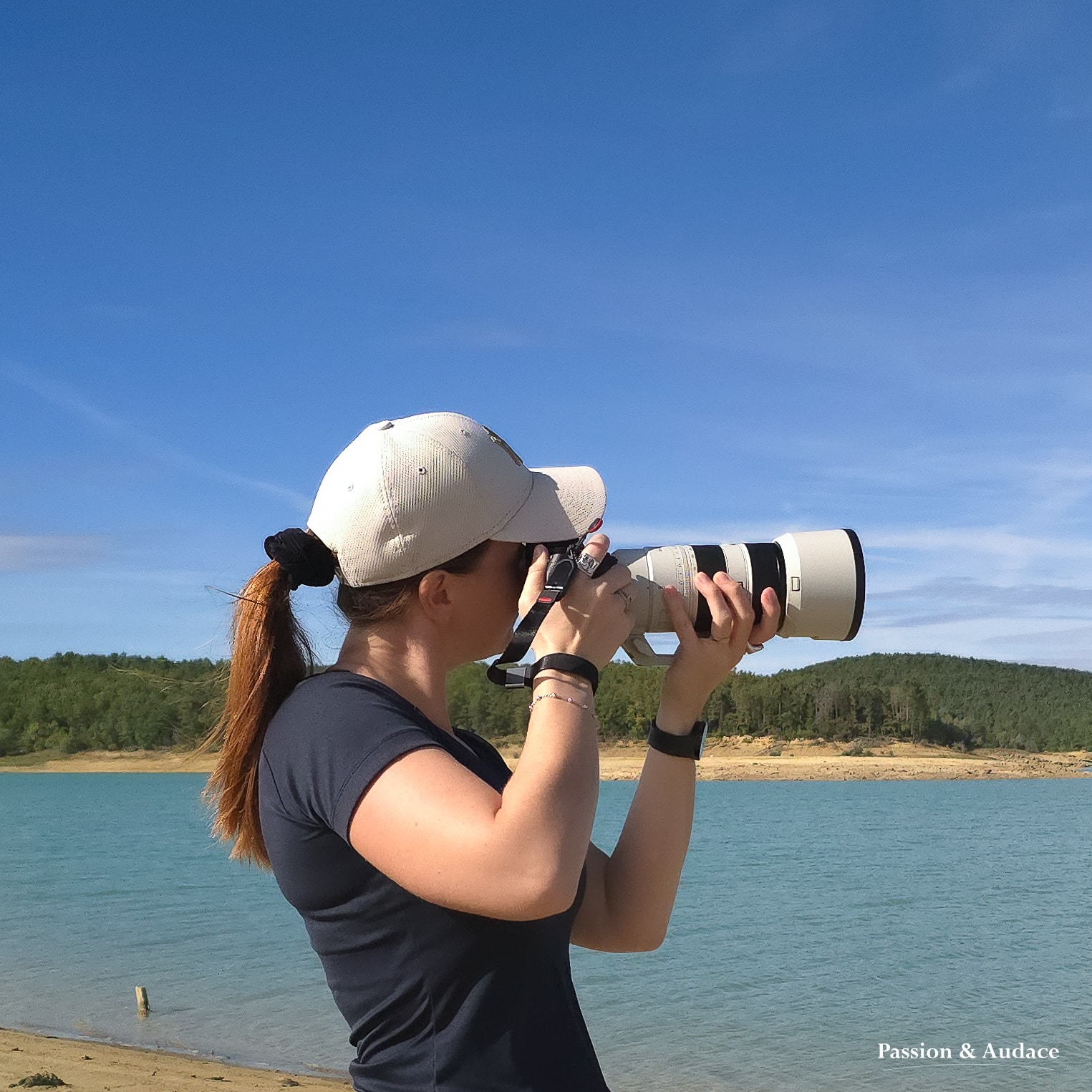 Photo d'une femme photographe en train de réaliser une photographie avec son appareil photo et téléobjectif