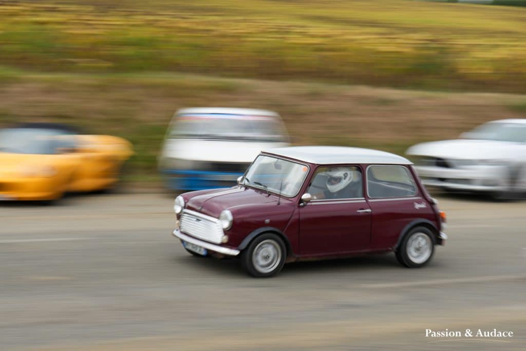 Photographie d'une Mini rouge bordeaux faisant la course sur le circuit de Cadours Laréole avec un effet de vitesse.
