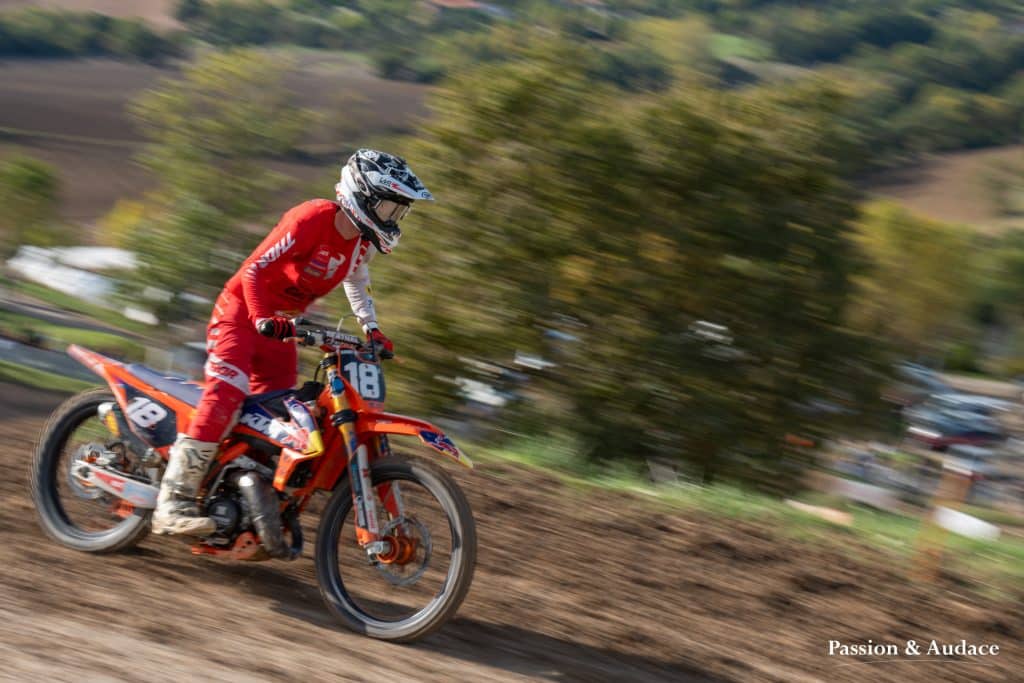 Photographie d'un pilote de cross en plein parcours avec un effet de filé de vitesse