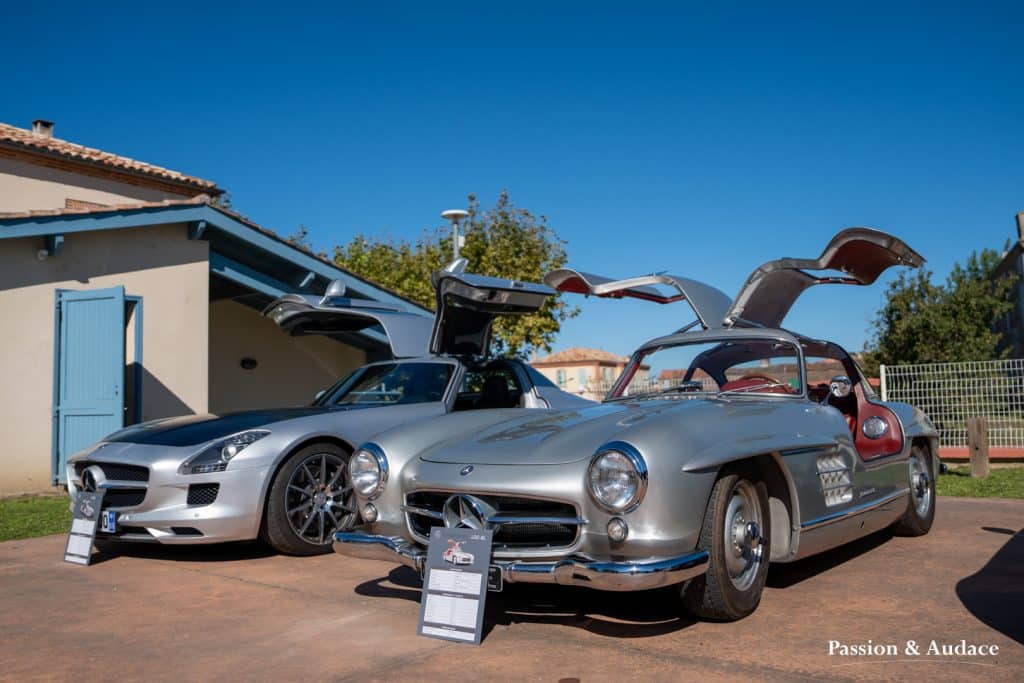 Photographie d'une Mercedes 300SL grise prise de 3/4 avec ses portes papillons en l'air.