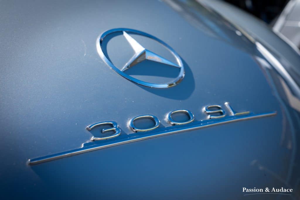 Photographie du logo d'une Mercedes 300SL grise.