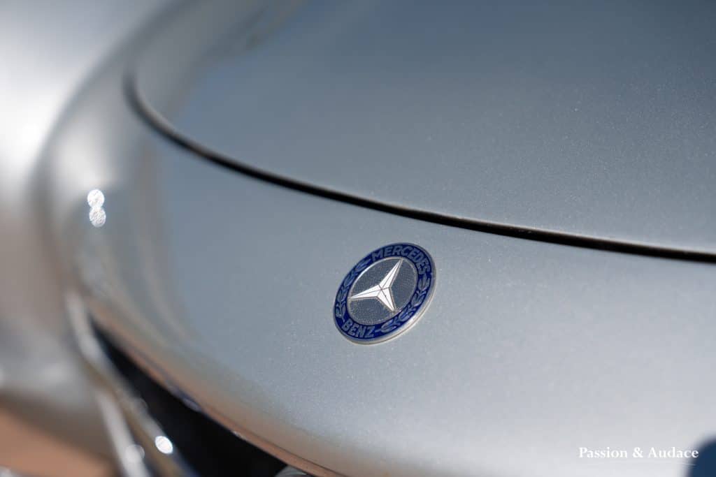 Photographie du logo d'une Mercedes 300SL grise.