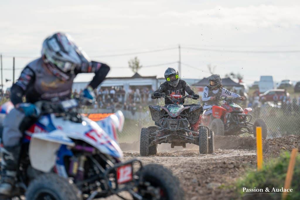 Photographie d'un pilote de quadcross en train de regarder son concurrent devant au 1er plan en pleine course