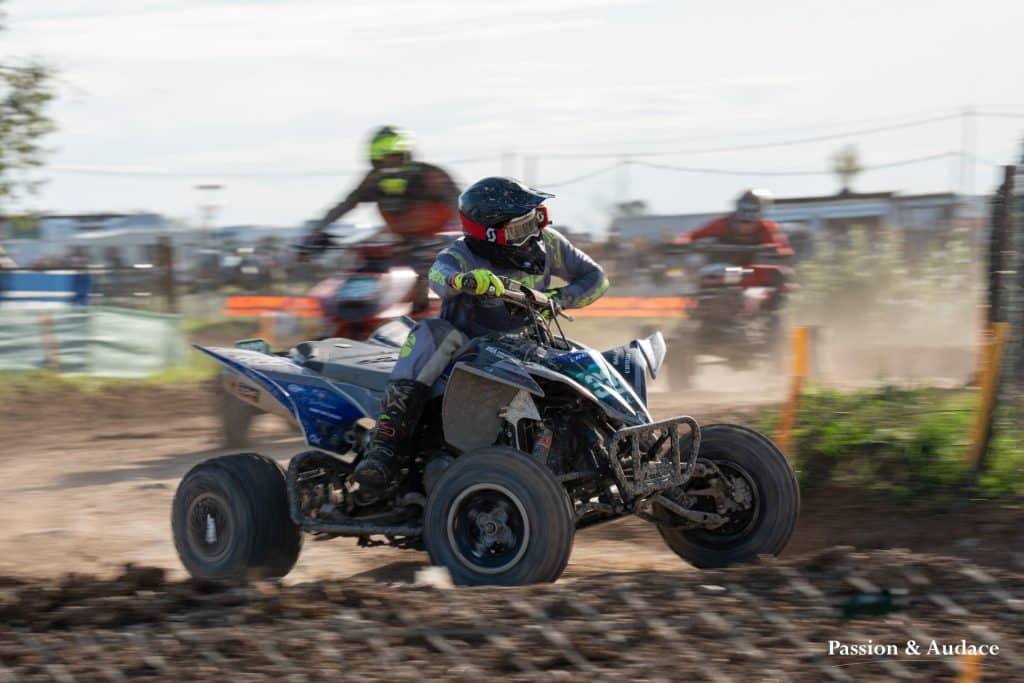 Photographie d'un pilote de quadcross en pleine course avec un effet de filée de vitesse